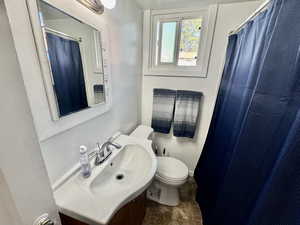 Full bath featuring vanity, a shower with shower curtain, and stone finish floors