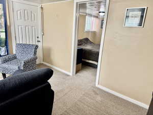 Sitting room with light colored carpet and baseboards