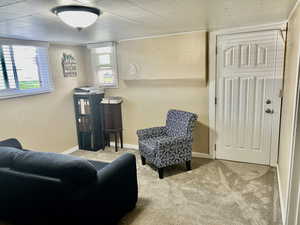 Living area featuring light colored carpet and baseboards