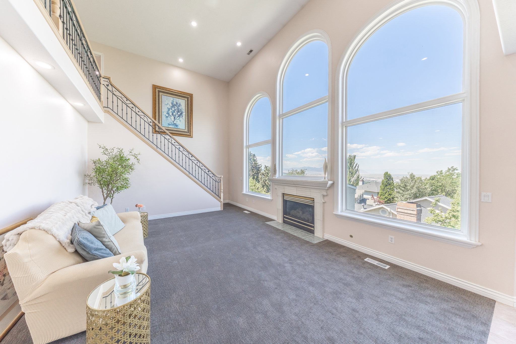 Living area featuring a high ceiling, carpet flooring, a fireplace with flush hearth, and recessed lighting
