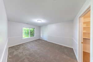 Empty room with carpet flooring and baseboards