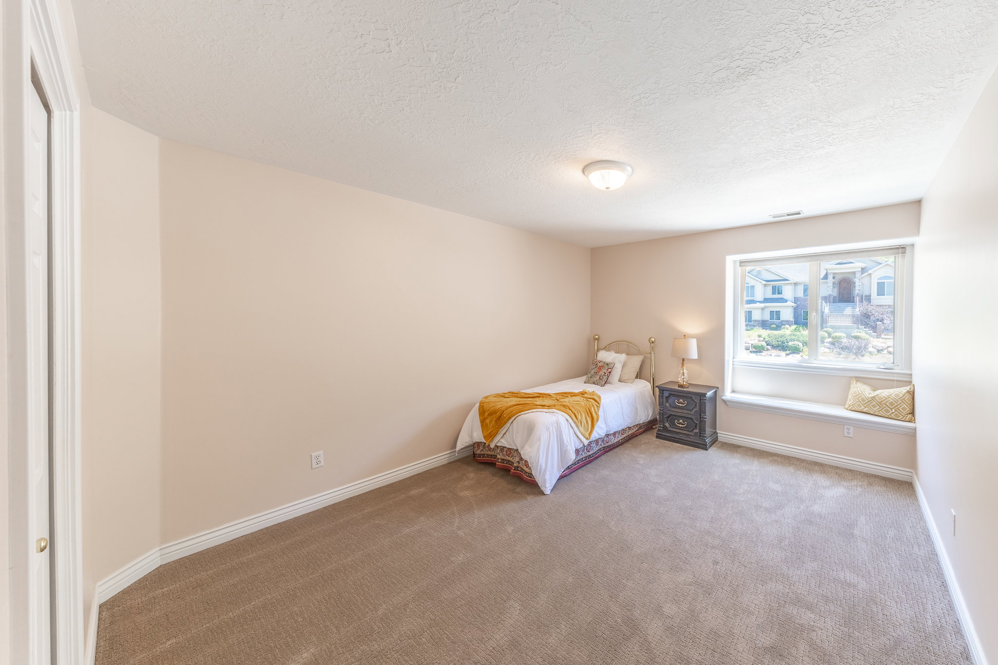 Carpeted bedroom with a textured ceiling and baseboards