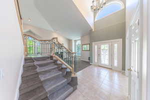 Entryway featuring light tile patterned flooring and a high ceiling