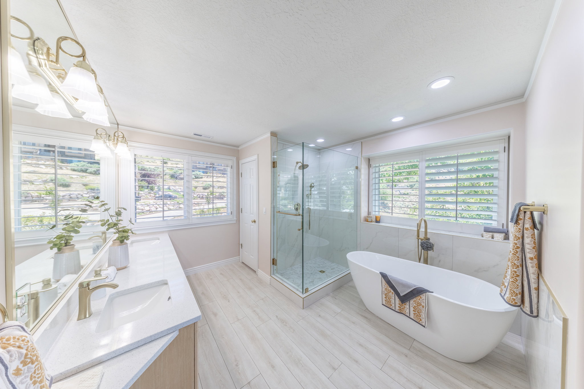 Full bathroom with double vanity, a soaking tub, a shower stall, ornamental molding, and recessed lighting