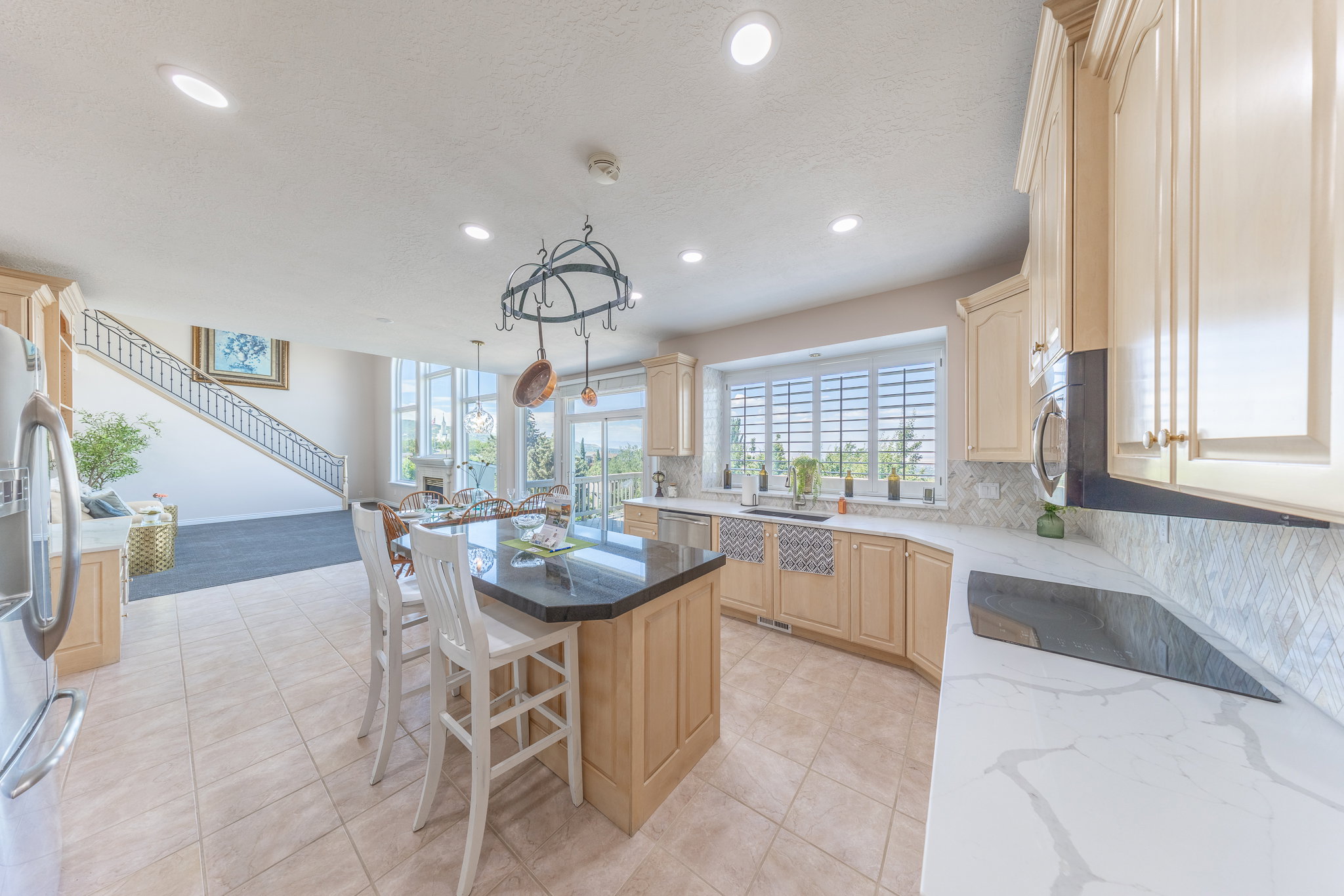 Kitchen featuring light wood finish cabinetry, stainless steel appliances, decorative backsplash, a kitchen island, and a kitchen breakfast bar