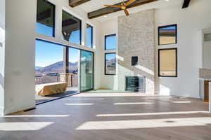 Unfurnished living room featuring a mountain view, a fireplace, light wood-style flooring, and healthy amount of natural light