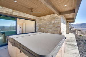 View of patio featuring a hot tub, ceiling fan, and a mountain view