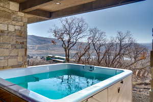 View of pool with a mountain view and a hot tub