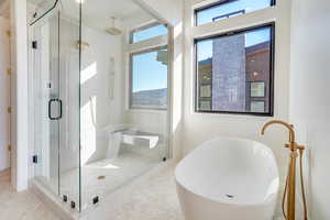 Full bath featuring a freestanding tub and a stall shower