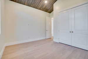 Unfurnished bedroom featuring a vaulted wooden ceiling, light wood-style flooring, recessed lighting, and a closet