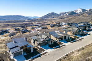 Aerial view of property and surrounding area with a mountainous background and nearby suburban area