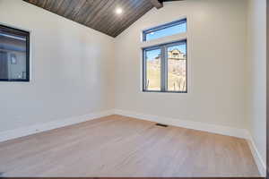 Empty room featuring lofted ceiling with beams, light wood-style floors, wood ceiling, and recessed lighting