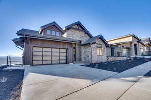 View of front of home featuring stone siding and concrete driveway
