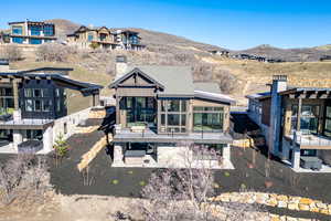 Back of property with a patio, a sunroom, and a mountain view