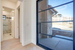 Full bathroom featuring light wood-type flooring, recessed lighting, and a marble finish shower