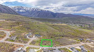 Aerial perspective of suburban area with mountains and property parcel outlined