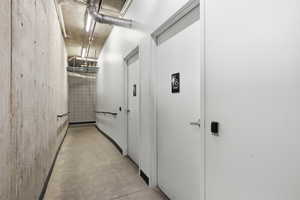 Corridor featuring unfinished concrete flooring