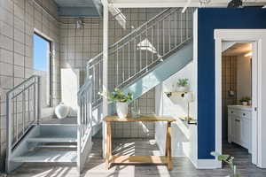 Stairs featuring wood finished floors and a high ceiling