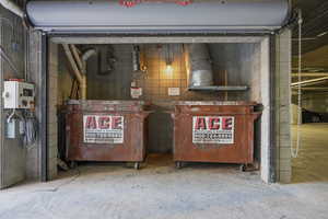 Detailed view of concrete flooring, concrete block wall, and related energy utilities