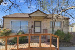 View of front facade with a deck and stone siding