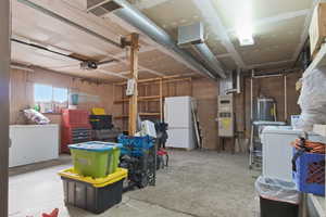 Garage with washer / dryer, freestanding refrigerator, fridge, a garage door opener, and concrete block wall
