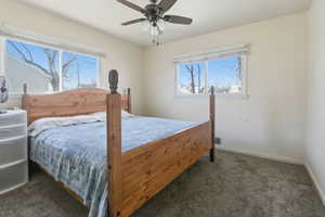 Bedroom with dark colored carpet and ceiling fan