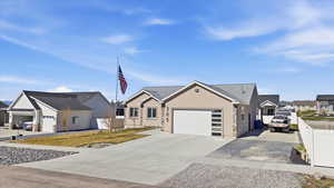 View of front of house with a residential view, a garage, driveway, and stucco siding