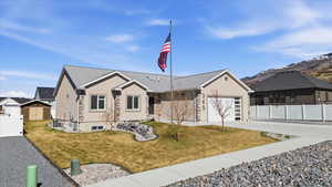 Ranch-style home featuring stucco siding, concrete driveway, a garage, and a mountain view