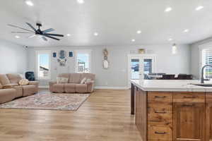 Living area with french doors, light wood-style floors, a ceiling fan, and recessed lighting