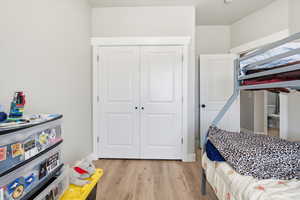 Bedroom featuring light wood finished floors and a closet