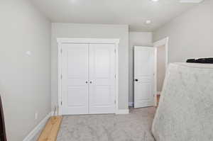 Unfurnished bedroom with light colored carpet and a closet