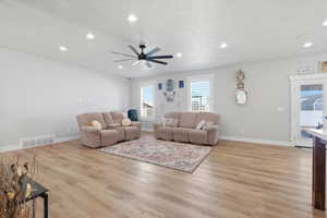 Living area featuring light wood-type flooring, ceiling fan, and recessed lighting