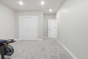 Exercise room featuring light carpet and baseboards