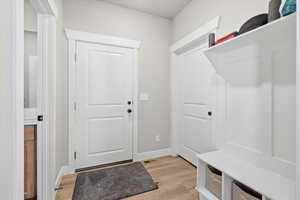 Mudroom with light wood-style flooring and baseboards