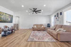 Living room with light wood-type flooring, a ceiling fan, and recessed lighting