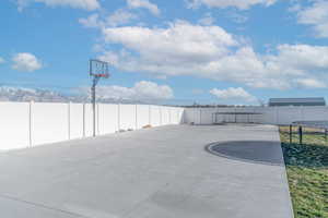 Fenced backyard with a trampoline and a mountain view