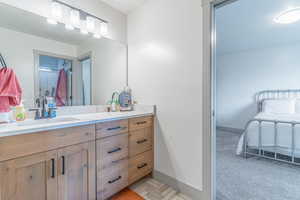 Full bathroom featuring vanity, ensuite bathroom, and light colored carpet
