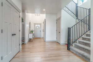 Foyer entrance with stairs and light wood-style flooring