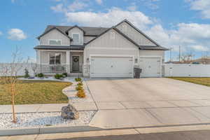 Craftsman house featuring board and batten siding, stone siding, a gate, and a porch