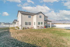 Rear view of property with a fenced backyard, a mountain view, a patio, a trampoline, and stucco siding
