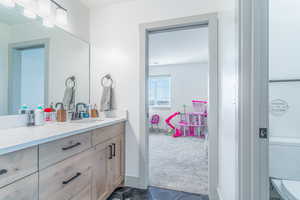 Bathroom featuring vanity, dark carpet, and dark tile patterned floors