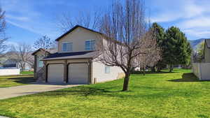 View of home's exterior with a garage and driveway