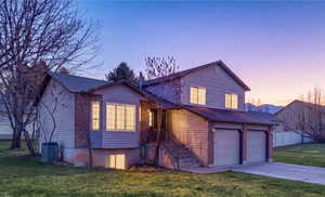 View of front of property with a garage, driveway, and brick siding