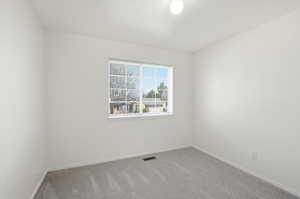 Unfurnished room with baseboards and light colored carpet