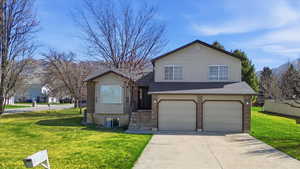 View of front of house featuring a shingled roof, concrete driveway, an attached garage, and brick siding