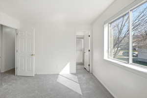 Unfurnished bedroom featuring light carpet and ensuite bath