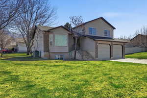 View of front facade featuring a front yard, concrete driveway, an attached garage, brick siding, and roof with shingles