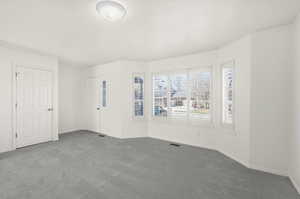 Empty room with dark carpet and baseboards