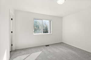 Unfurnished room featuring light colored carpet