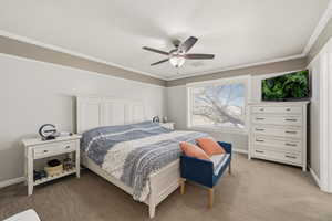 Bedroom featuring light colored carpet, crown molding, and ceiling fan